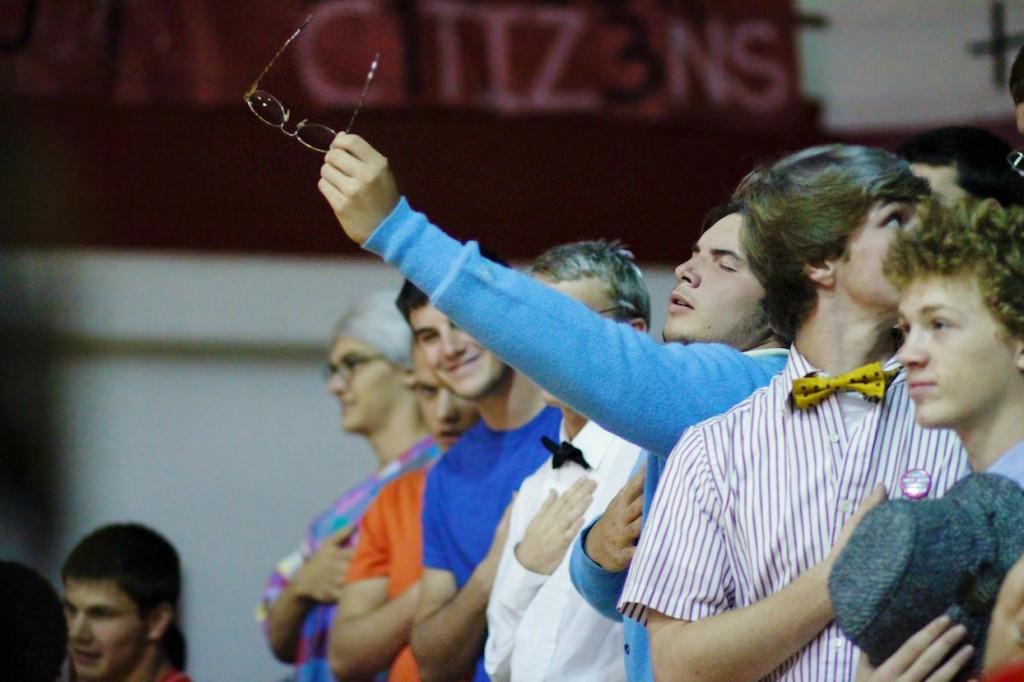 Joshua Brentlinger holds out his glasses during the National Anthem. 