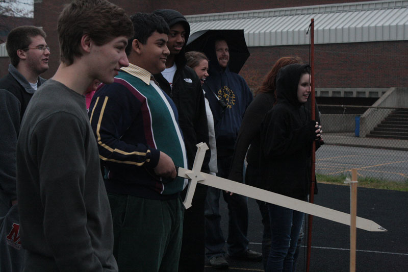Students+of+Mr.+Garretts+Global+Issues+class+watch+their+peers+test+out+their+homemade+weapons.+Omar+Mostafa+%2811%29+holds+the+sword+he+brought+in+for+the+project.