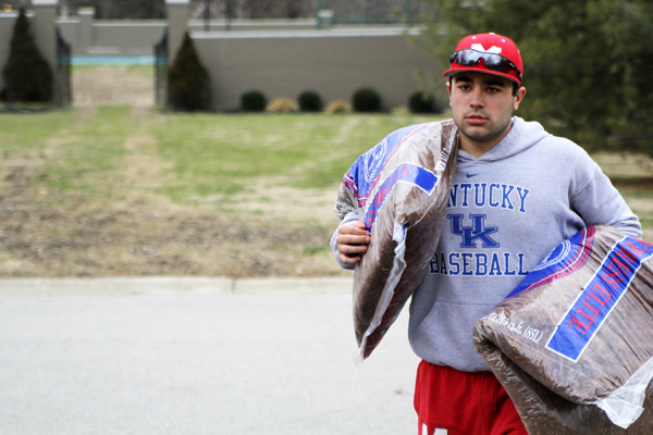 Nathan Smith (12) carries bags up a driveway. 