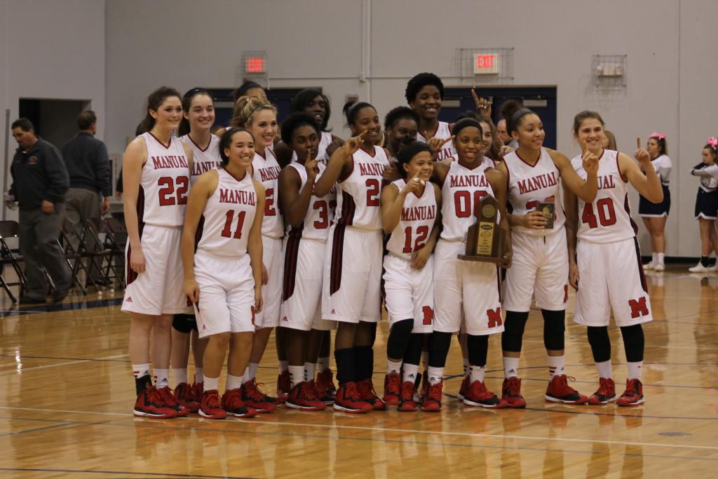 The Lady Crimsons pose with their trophy after winning the district tournament. Manual will now advance to the regional tournament.