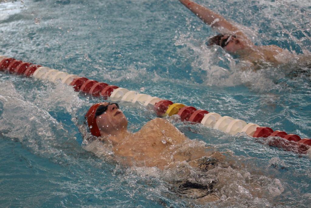 Graham Jolly swims neck-and-neck with St. Francis swimmer Clayton Smedley. Smedley beat Jolly by a single second with a time of 33.04 seconds. Photo by Kate Hatter.