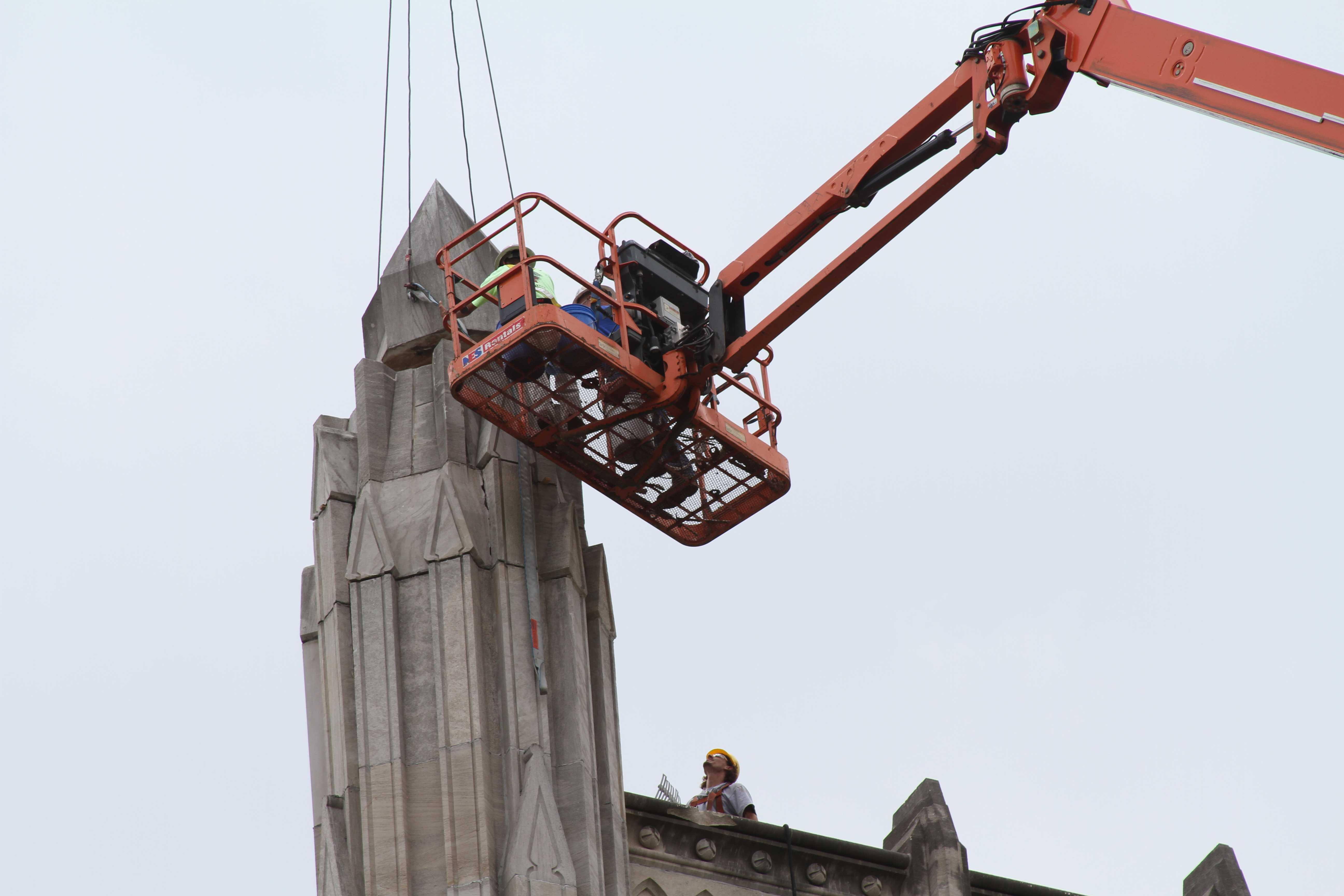 Contractors replace the center stone of Manuals iconic tower