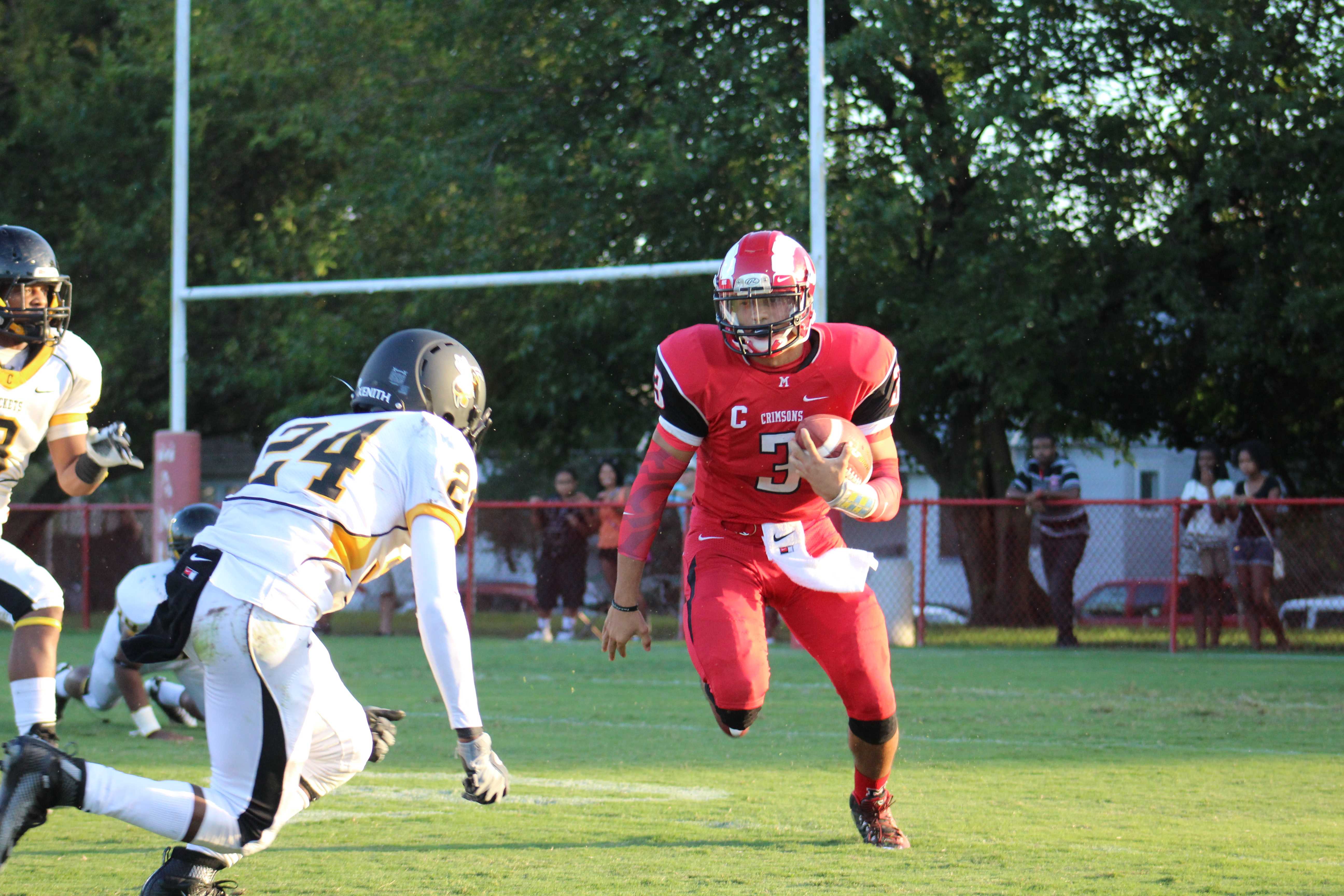 Quarterback Tim Comstock (12, #3) runs for a gain of four at the beginning of the first quarter. Photo by Kate Hatter 