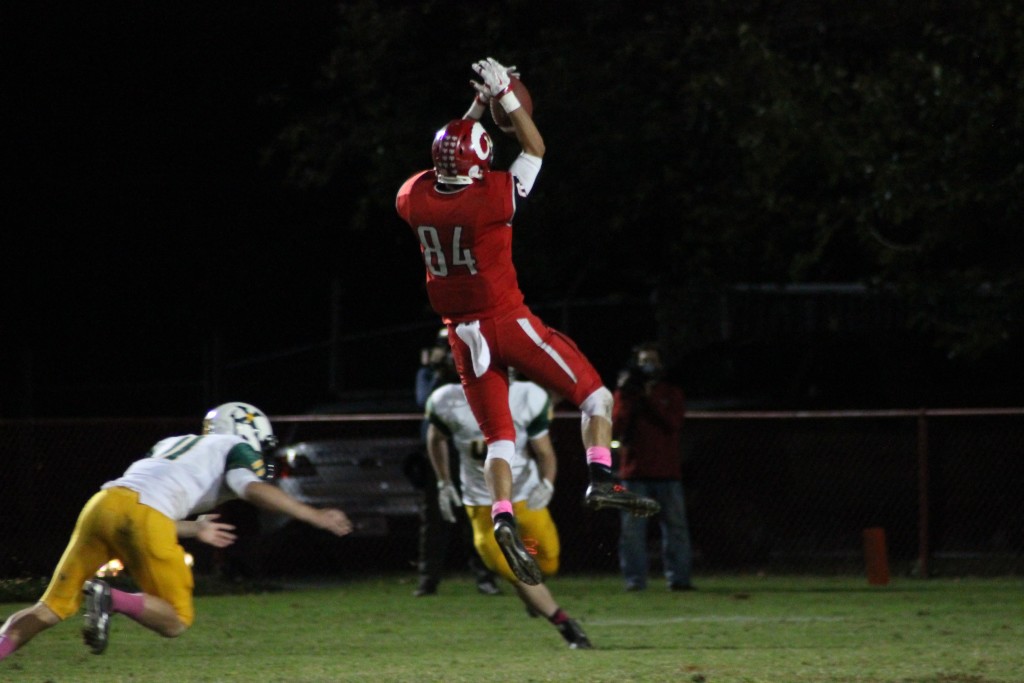 Eric Neimann (12, #84) catches a high pass early in the fourth to give the Crimsons some life. Photo by Roshan Duggineni