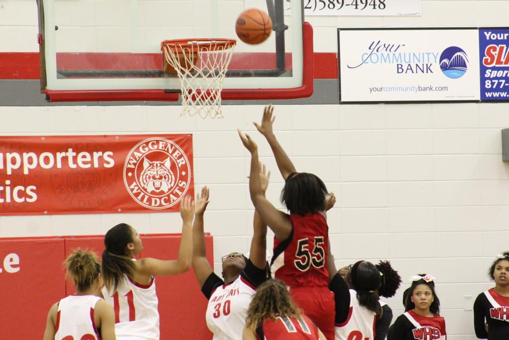 Krys McCune (12, #55) uses her height advantage to score over smaller Waggener defenders. Photo by Kate Hatter.
