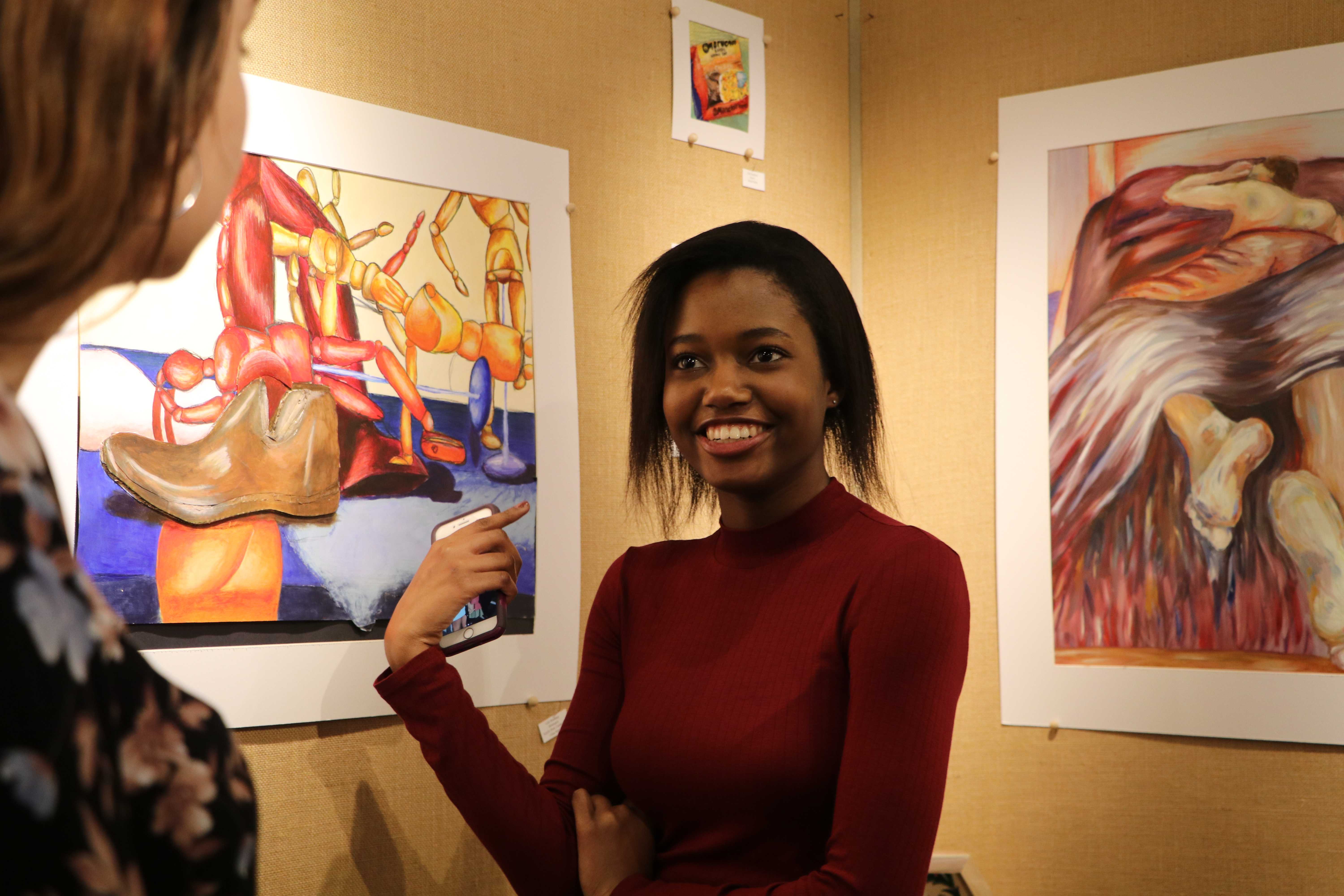 Laurie Jonhatan (12, J&C) cheerfully discusses the artwork with her friend, Olivia Dawson (12, J&C). Photo by Grace Bradley. 