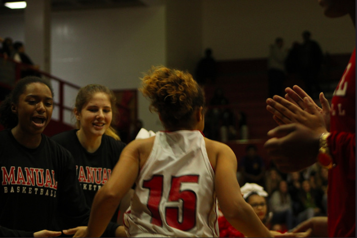 Jeanay Riley (11, #15) runs onto the court after being introduced as a starter. Photo by Sophia Allen.