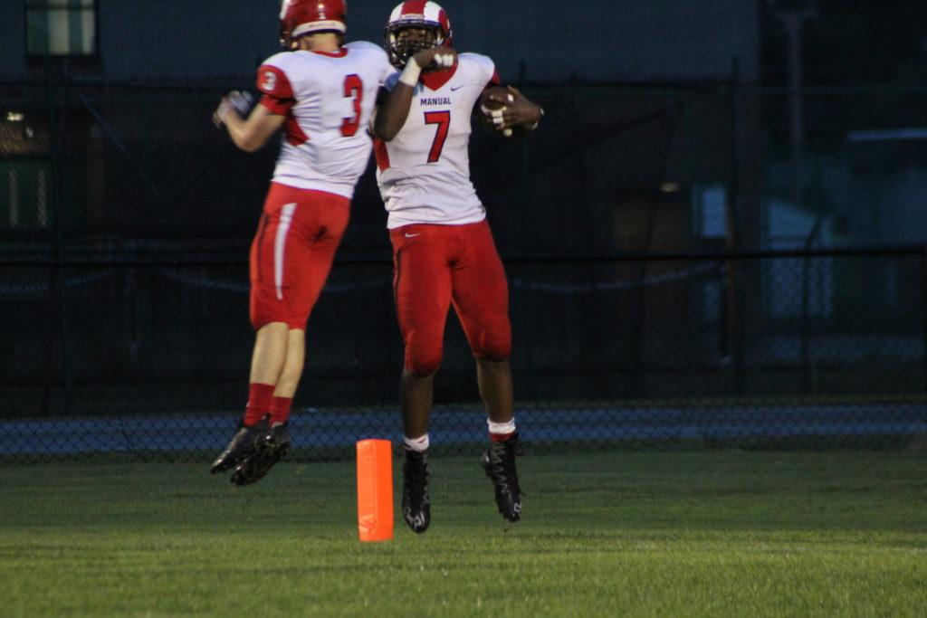 Two Manual football players celebrate after a touchdown. Photo by Maya Joshi.