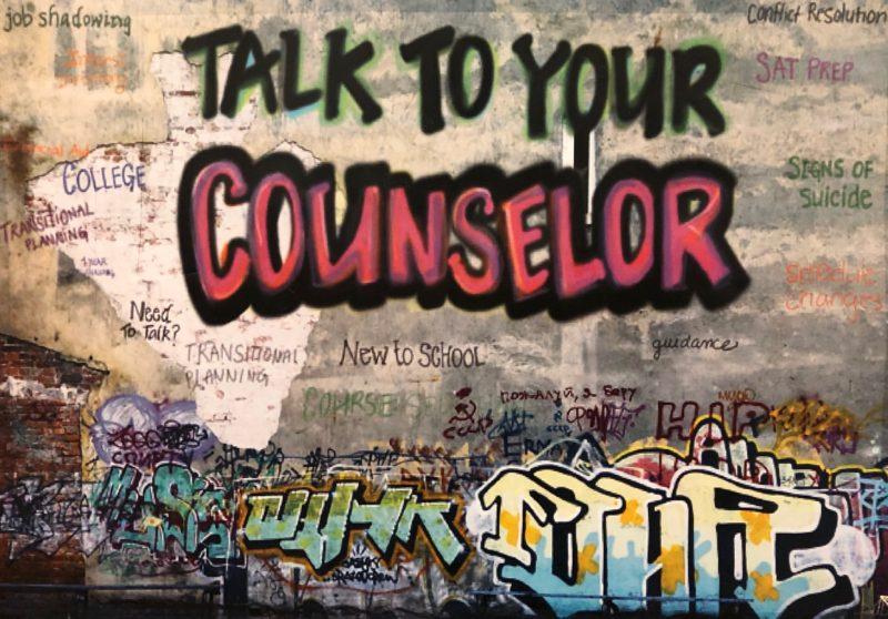 A grafitti-styled painting on the wall outside Manuals guidance office reminding students to Talk to your counselor.
