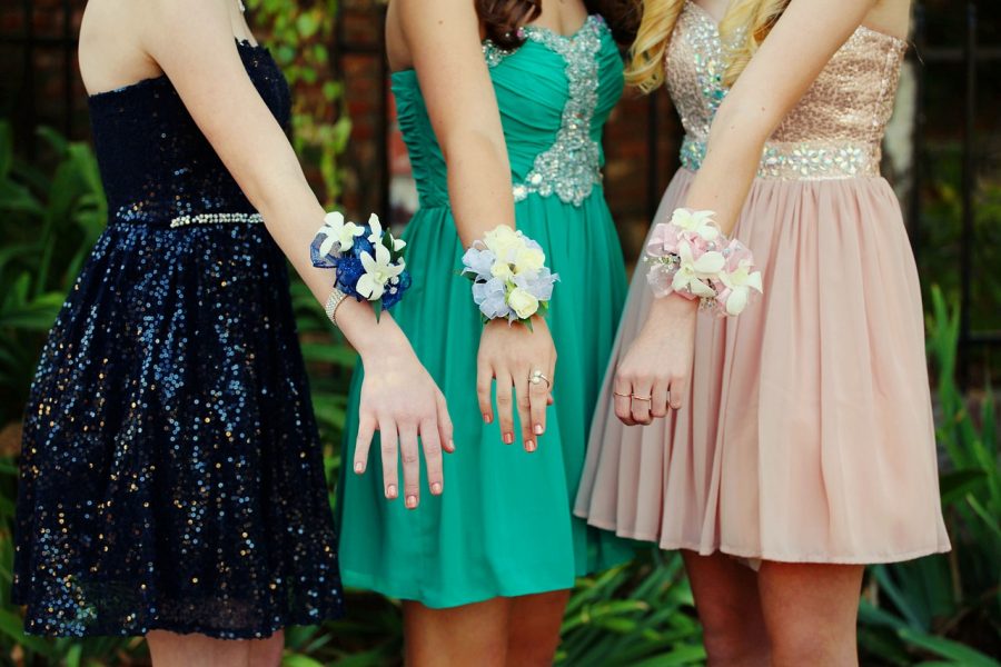 Three+girls+pose+with+their+corsages+before+homecoming+2019.+
