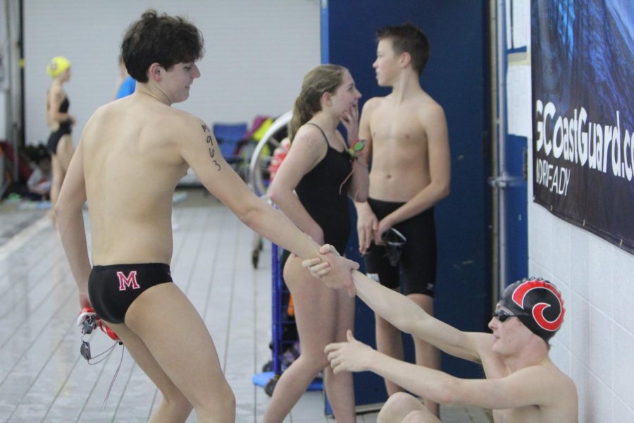 Hayden+Brown+%2812%2C+MST%29+helps+his+teammate+Daniel+Pearson+%2812%2C+HSU%29+off+thr+ground+to+prepare+for+a+race+at+Mary+T.+Meagher+Aquatic+Center.+Photo+By+Raegan+Reisert