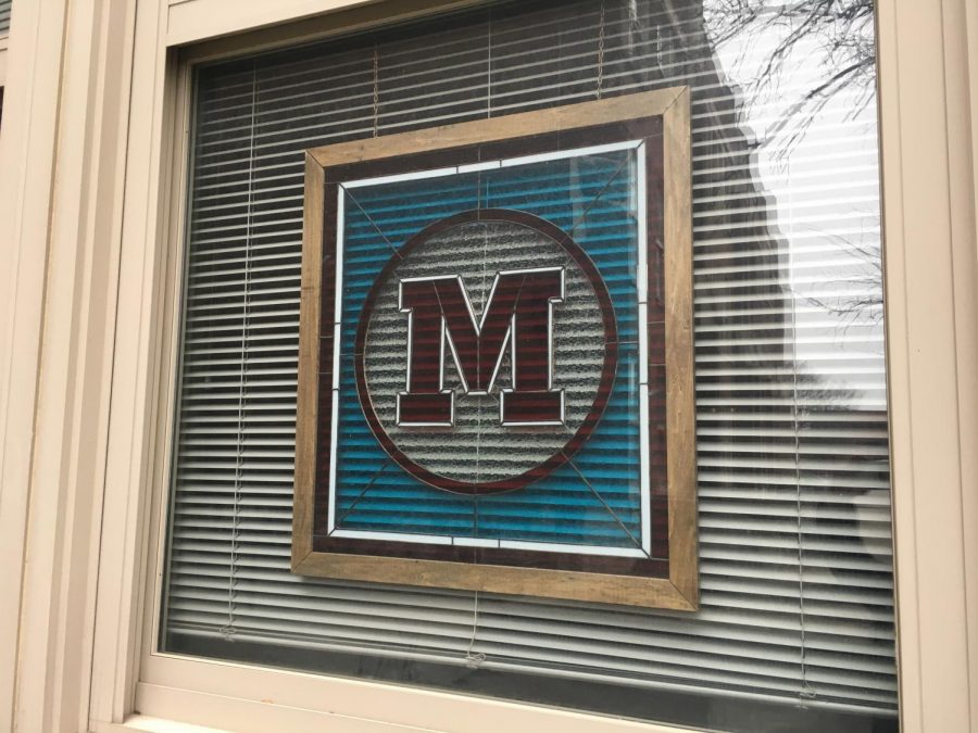 Stained glass outside of the principals office representing M for Manual. Photo by Jay Miller.