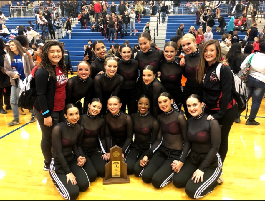 The Dazzler team sits together for a photo with the trophy. This trophy is for their win in the Small Hip Hop category. They placed in one out of two of their dances. Photo by Cassidy Adwell.
