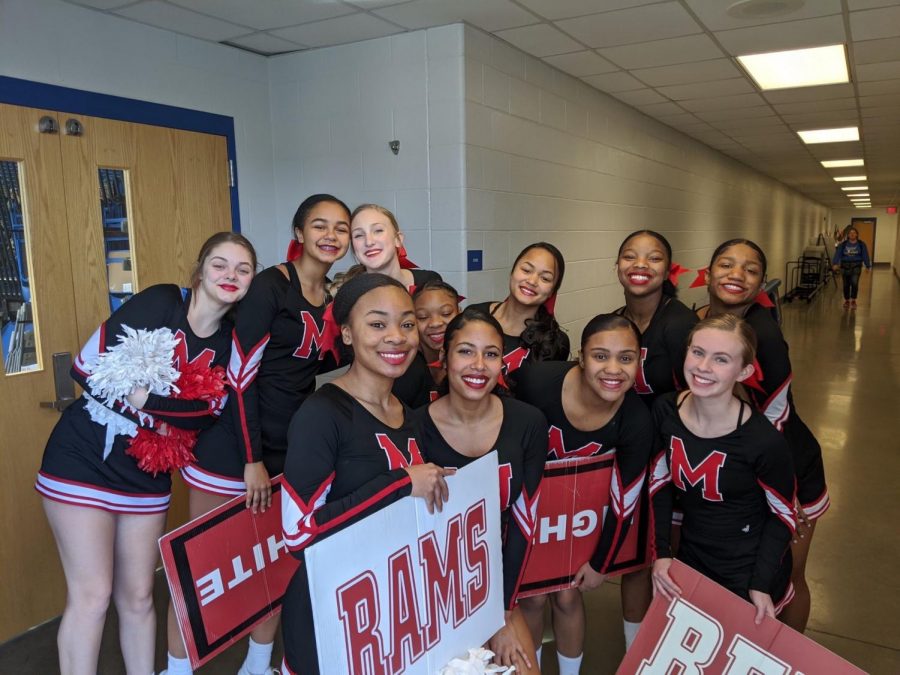 Manual’s cheer team huddles together for a picture before going out on the mat. Photo by Abigail Sanders.
