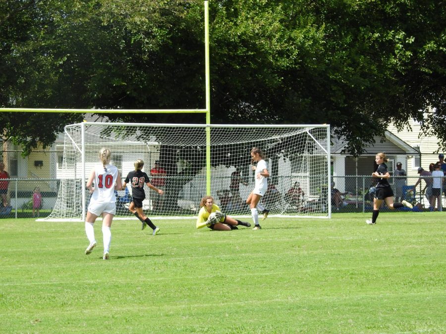 Manuals Kylie Seraphine (12, #1) launches to catch the ball blocking the St. Henry goal. Photo by Yaara Aleissa.