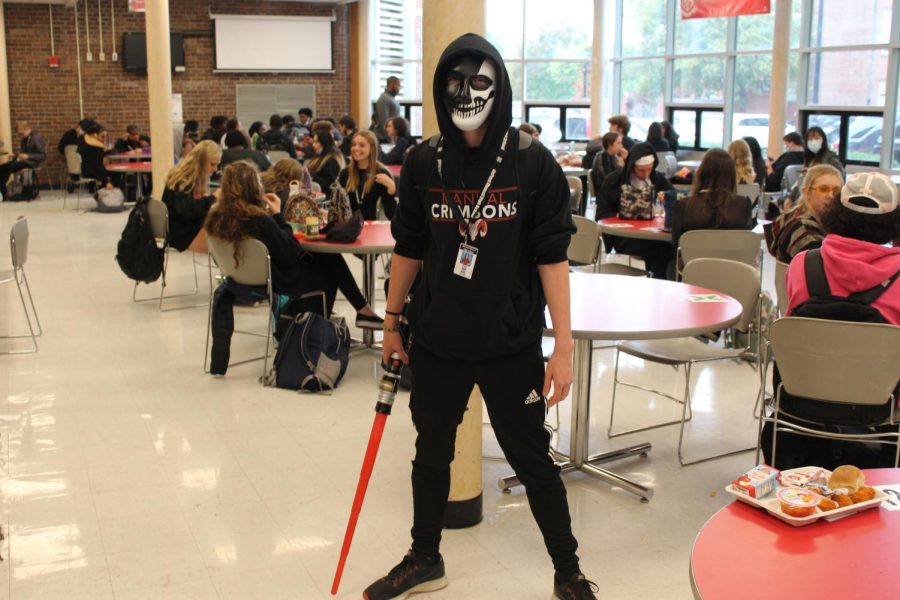 Colin Barth (12, HSU) poses in the senior cafeteria with a lightsaber. Photo by Justin Farris.