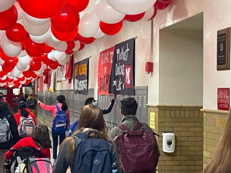 Manual student adjusts R/W Week decorations before heading to class.