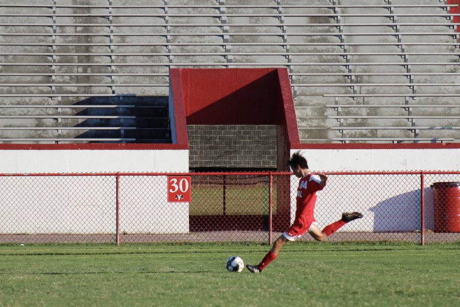 Shoma Lowber (12, HSU) prepares to strike a cross in a game during his sophomore year. Photo by Molly Gregory.