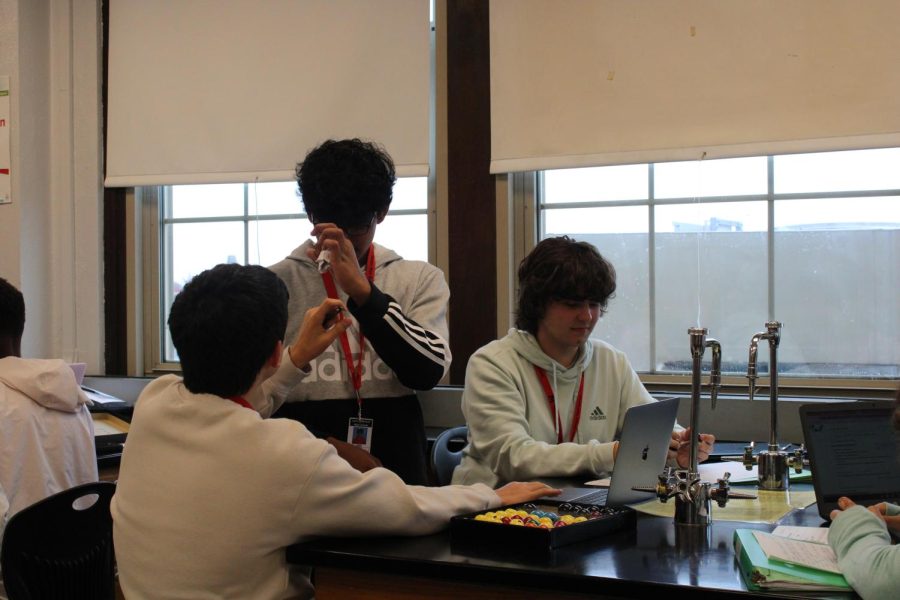 Three+students+participate+in+a+lab+in+Mr.+Redies+chemistry+class.+Photo+by+Bri+Woods