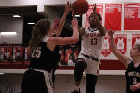 Ashlinn James (11, #13) jumps up to try and gain points for Manual. Photo by Morgan Schmidt
