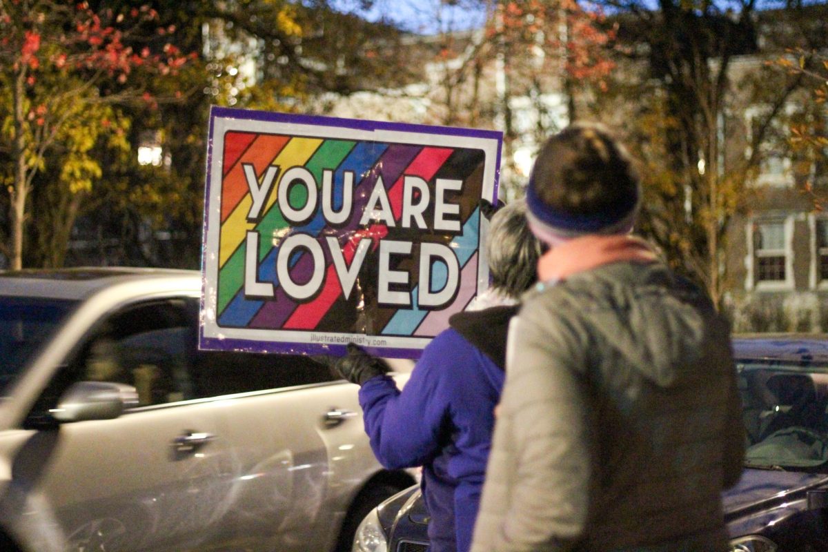Counter-protestors+holding+a+sign+that+says+You+are+Loved+as+cars+pass+by.+Photo+by+Ava+Blair