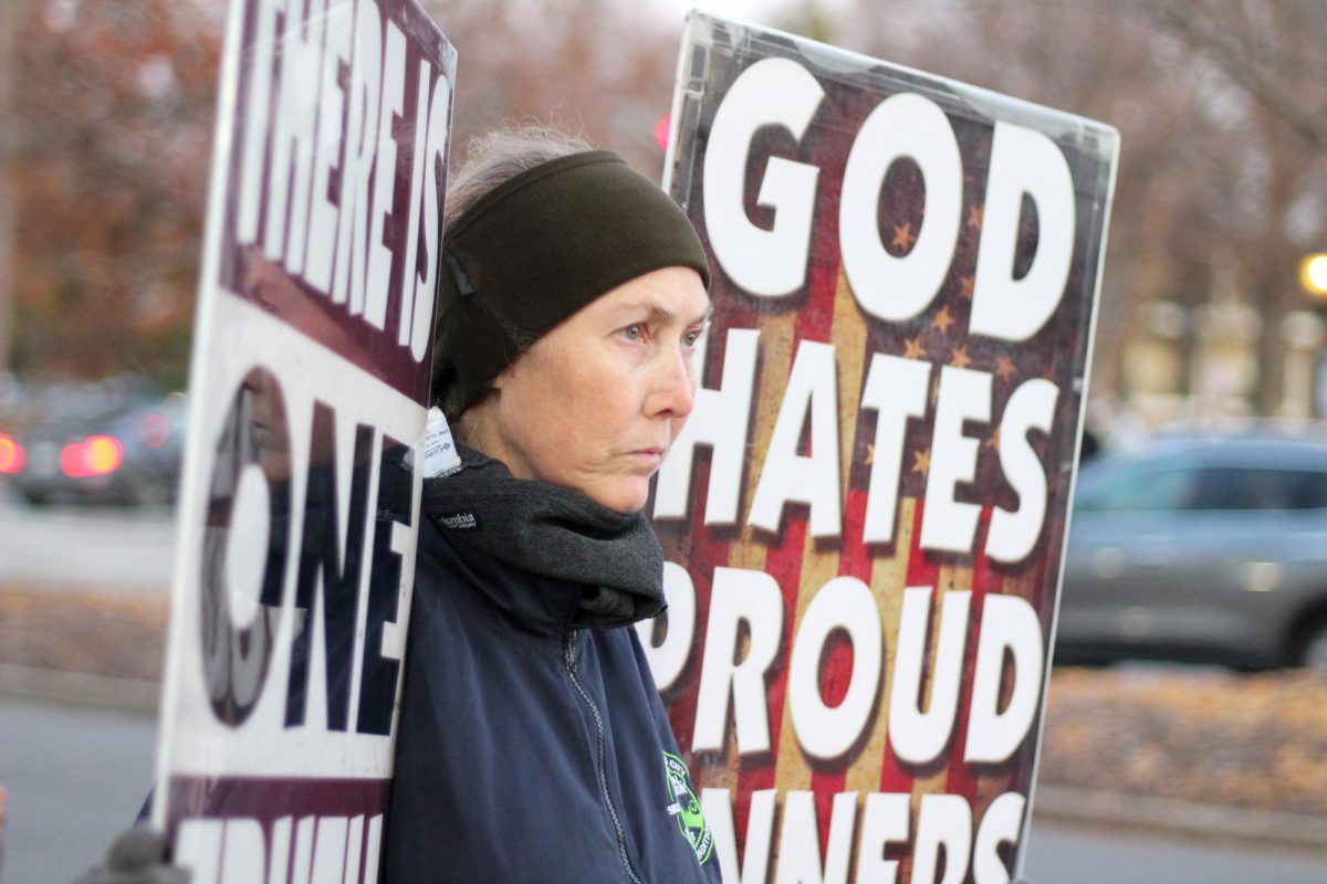 A member of Westboro Baptist Church holding a sign that says God hates proud sinners.