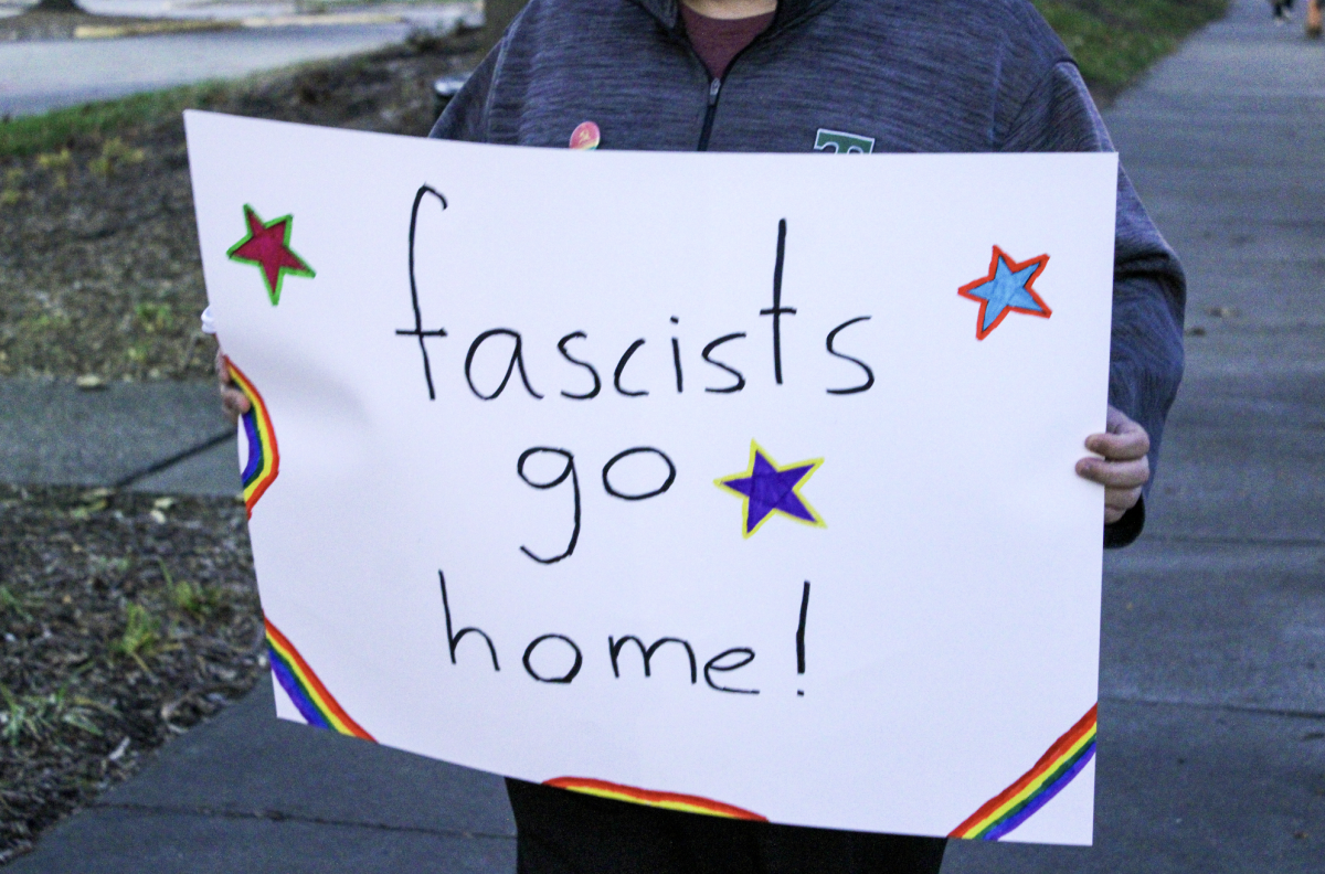 A counter-protestor with a sign that reads Fascists go home!