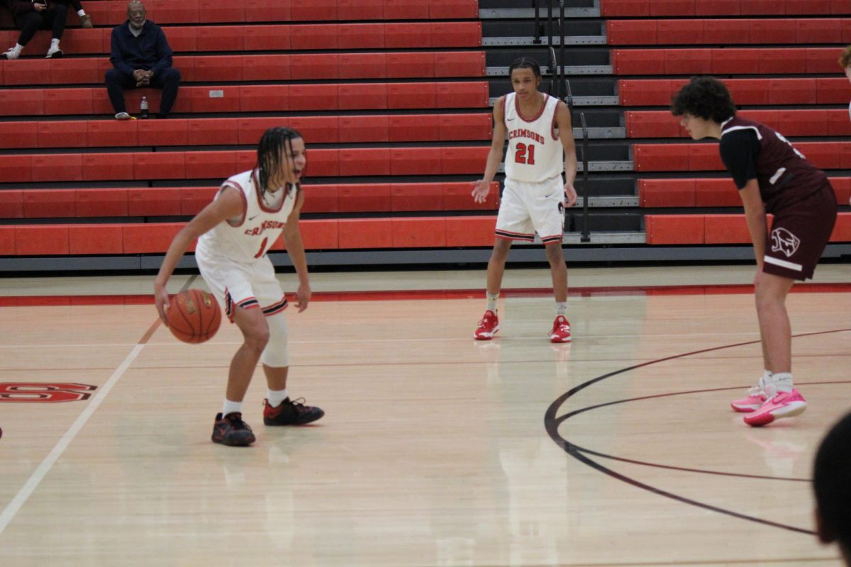 A Manual player dribbling the ball down the court and looking for options.