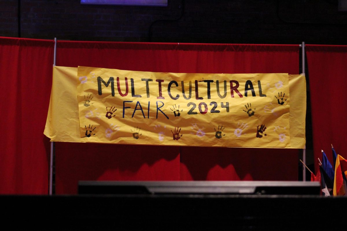 The sign for the multicultural fair displayed in the auditorium.
