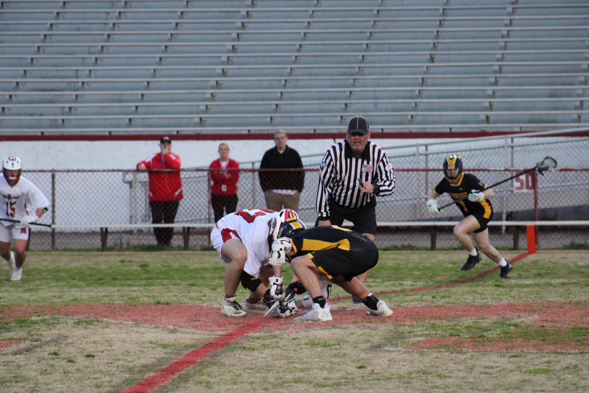 Luca Bowling (#37, 12) doing the face-off against a Woodford player. Photo by Lydia Adams