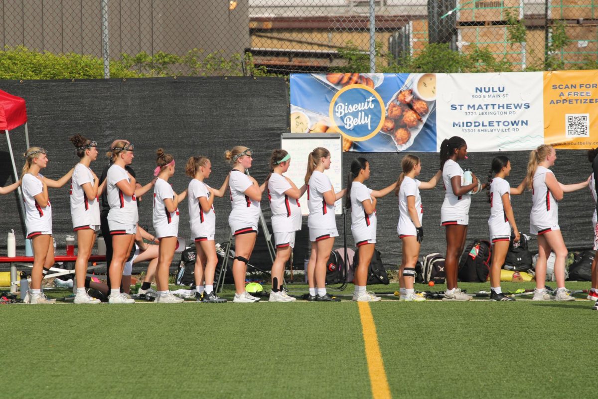 The girls' lacrosse team standing for the National Anthem before their game. Photo by Lydia Adams