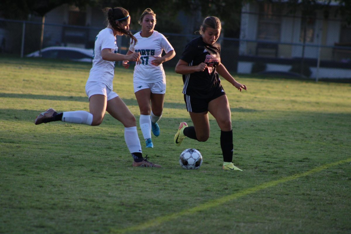 Mai Bajic (#6, 12) attempts to evade North Oldham forwards.