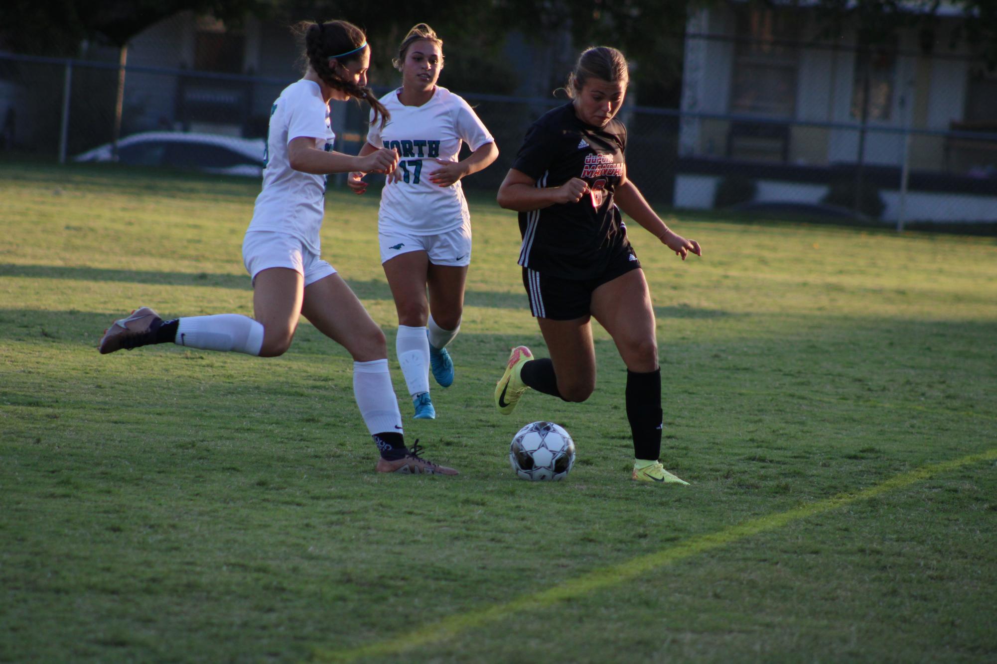 Mai Bajic (#6, 12) attempts to evade North Oldham forwards.