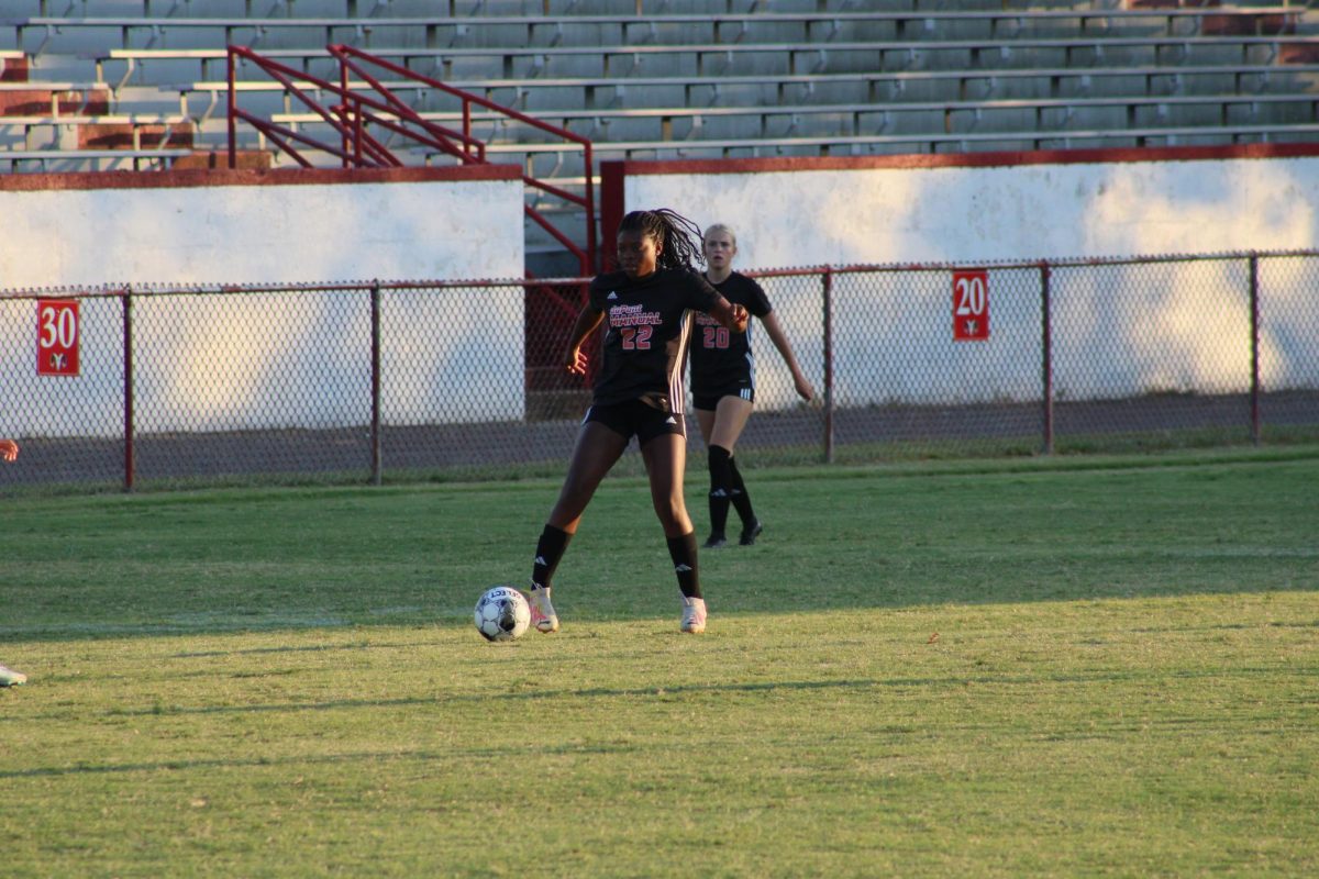 Jasmine Smith (#22, 11) stops the ball and looks to pass up field.