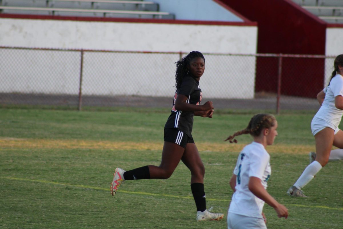 Jasmine Smith (#22, 11) runs up the field watching play happen from the other side of the field.