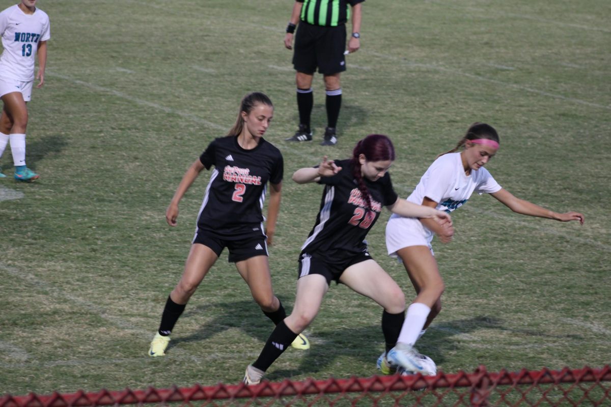 Isabelle Hooper (#28, 11) tries to get the ball from a North Oldham player, while Emma Griffin (#2, 12) supports her from behind.