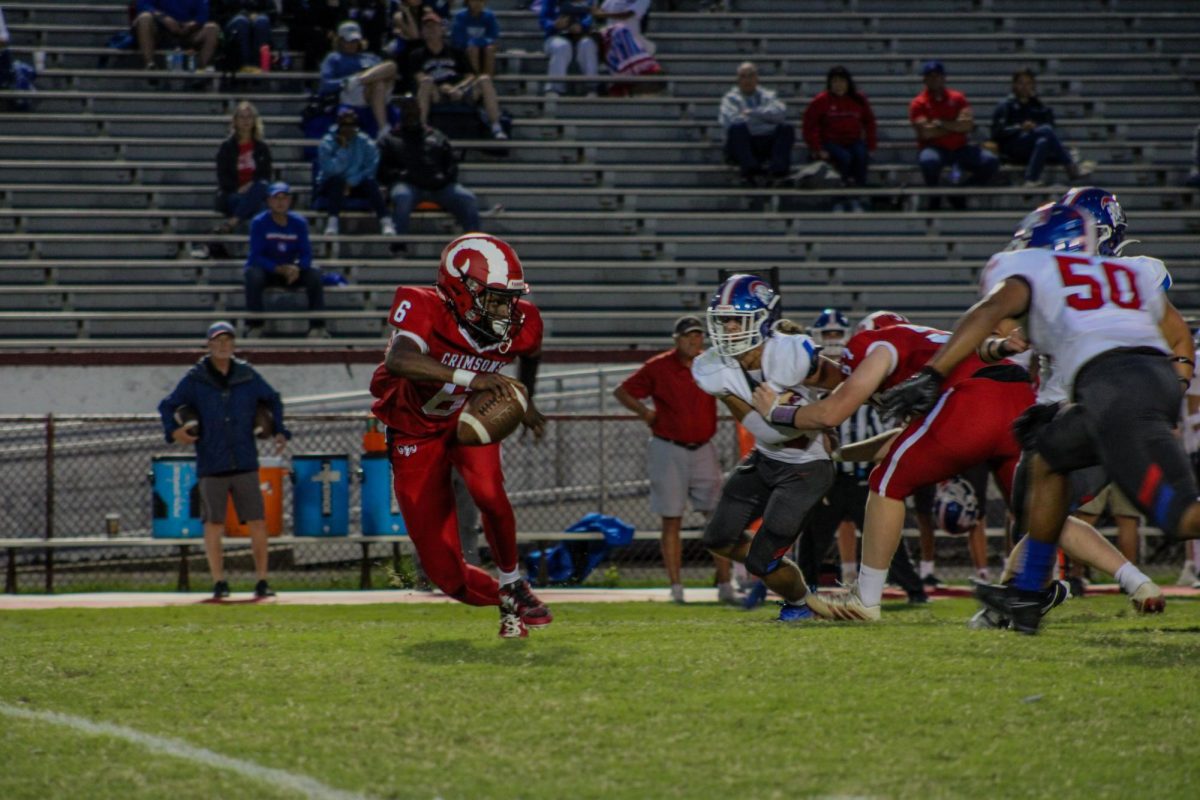 Kaden Mack (#6,10) scrambles from the pocket while being pressured by Christian Academy.