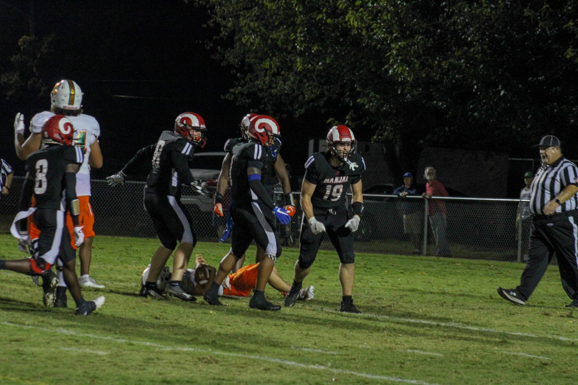 Cameron Jessee (#19, 12) looks to the sideline and shouts in success after making a big tackle. 