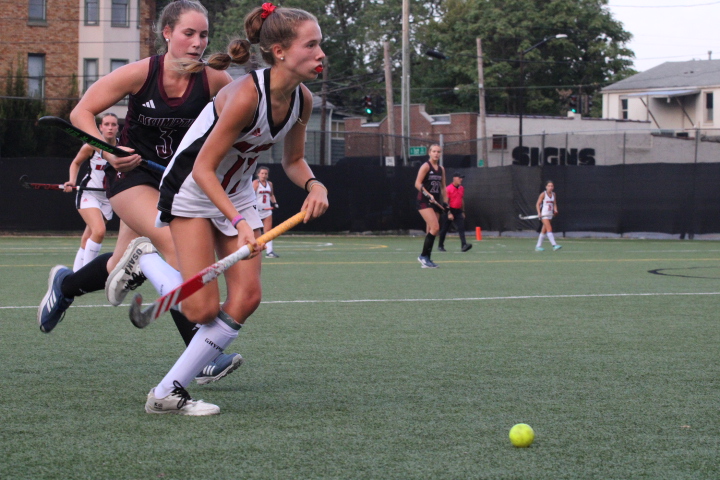 Charlotte Connally (#17, 11) looks up the field to pass the ball. 