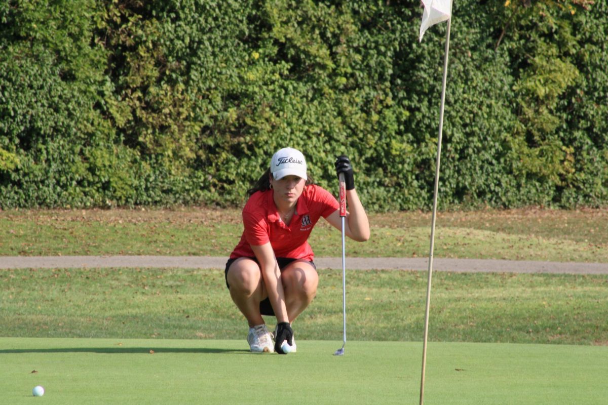 Ella Sizemore studies the green and places her ball on the ground prior to putting. 