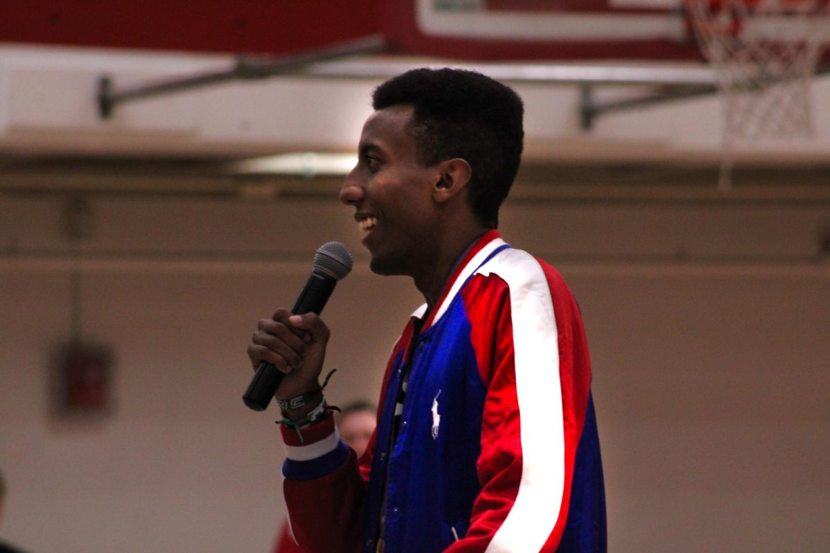 Yared Nuguse speaks to the crowd in Manual's gym, a smile on his face. 