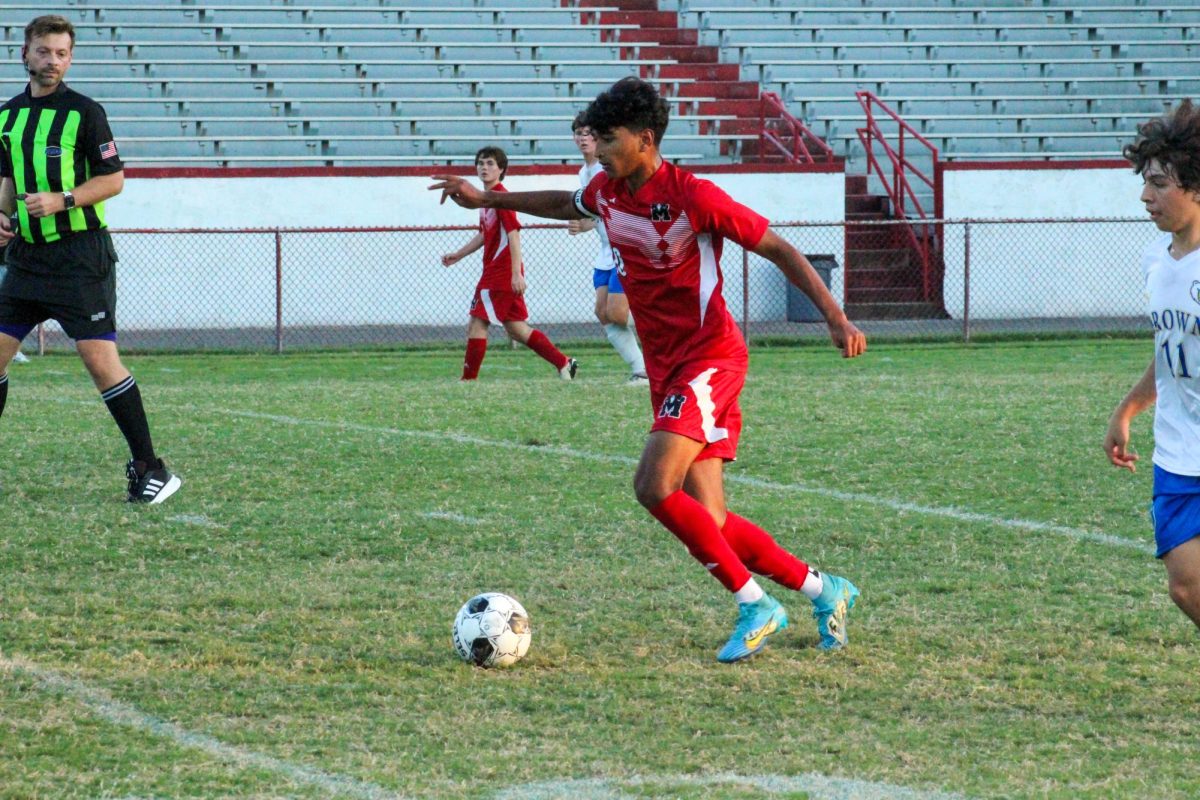 Ibrahim Piracha (#10, 12) dribbling the ball up the field.