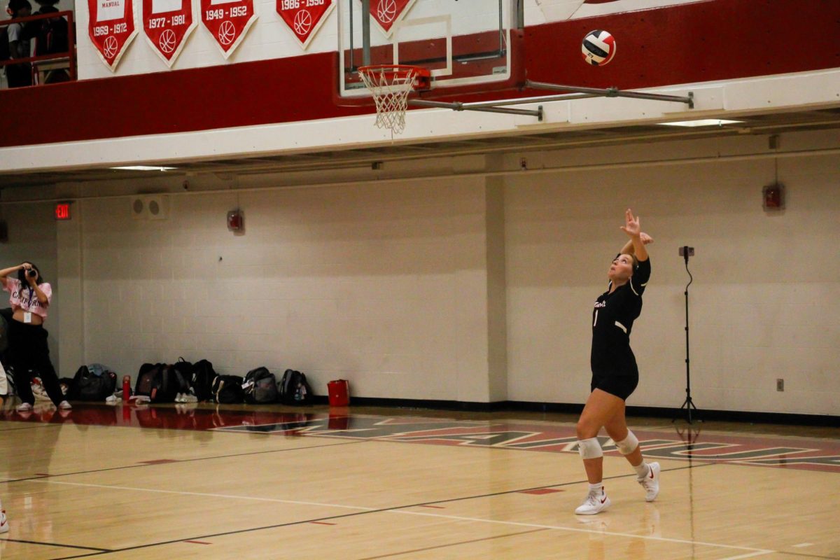 Kennedy Dawson (#1, 12) serving the ball. Photo by Safa Saedi