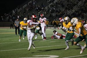 Gerian Traynor (#34, 11) runs with the ball in his hand, evading St. X defensivemen.