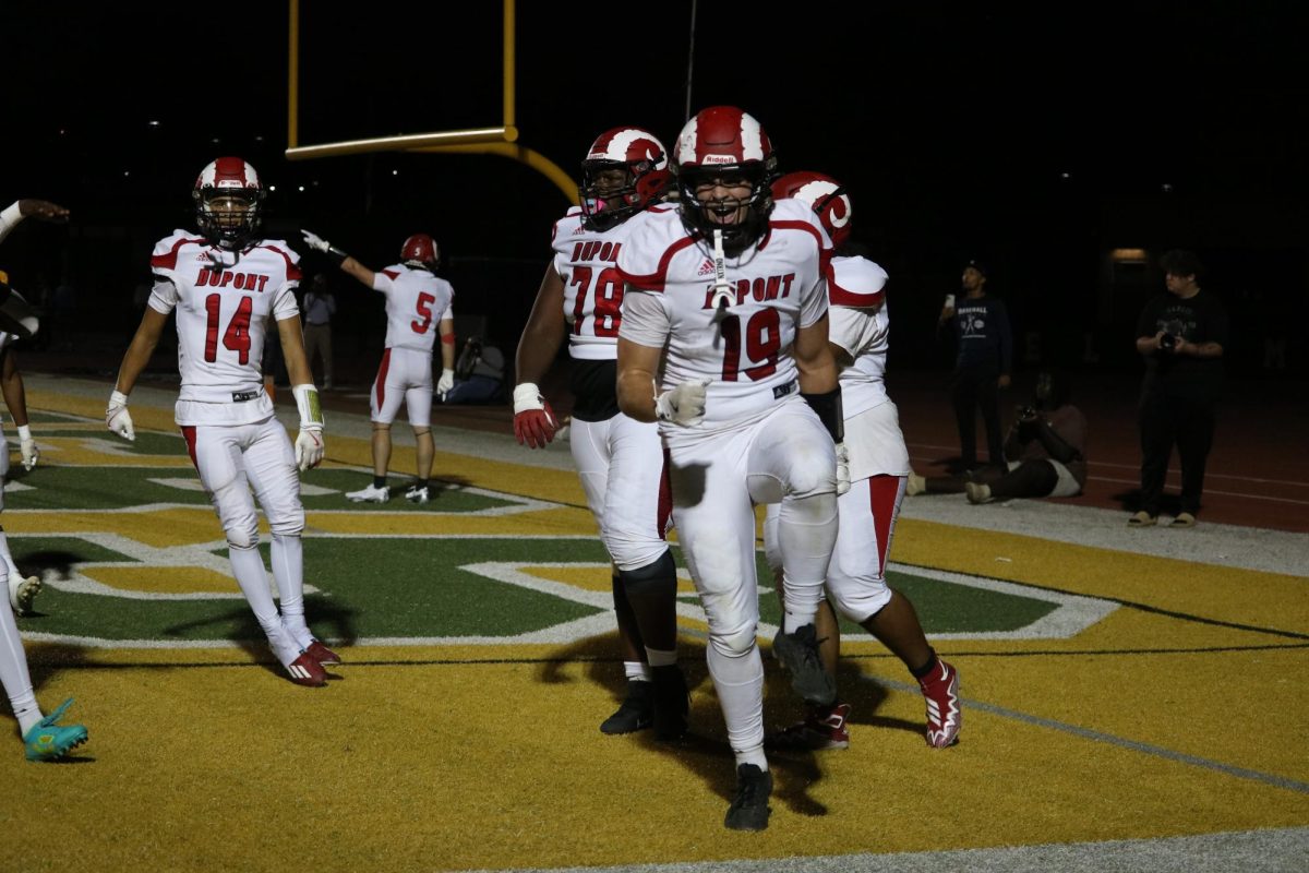 Cameron Jessee (#19, 12) shouts in excitement after scoring a touchdown in the end zone. 