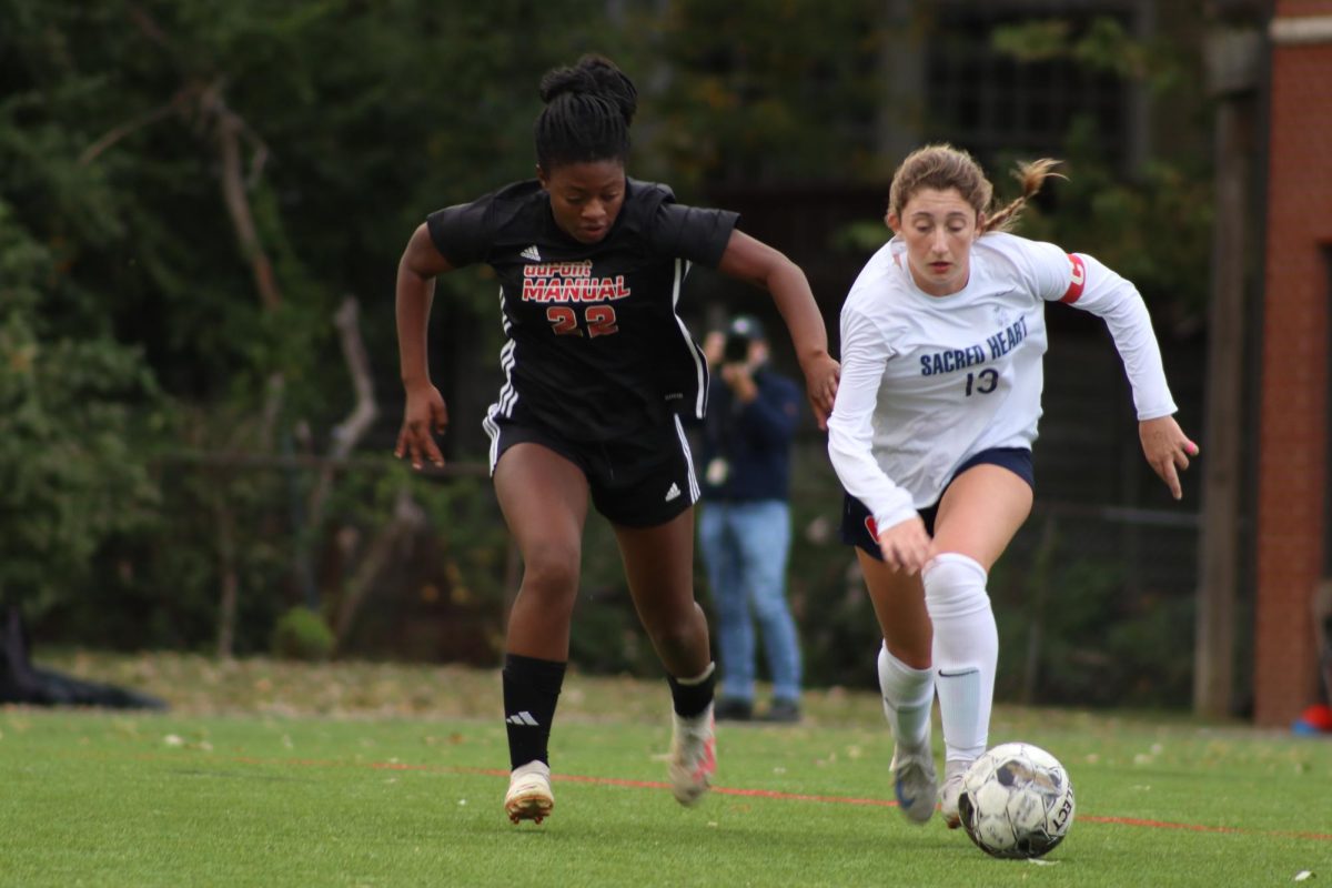 Jasmine Smith (#22, 11) races after the ball, a Sacred Heart player by her side. 