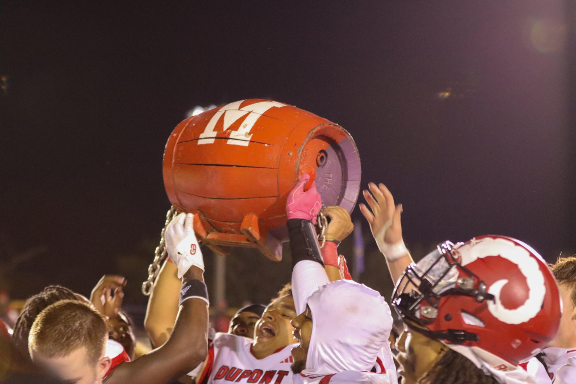 Manual's football team celebrates their win against Male with the barrel. 