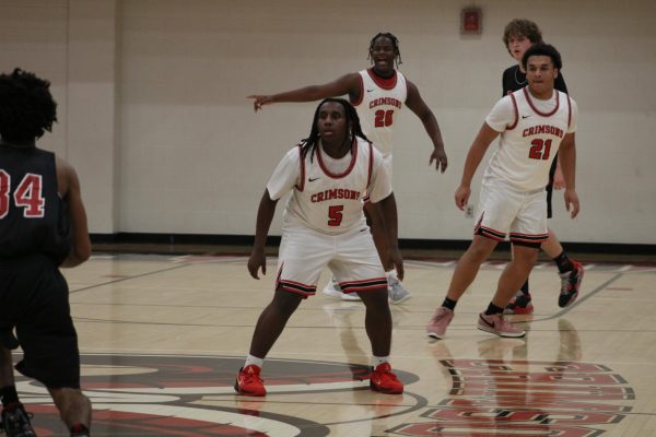 Jesiah Flippins (#5, 9), Leslie "CJ" Hall (#33, 10) and Jeremiah Stephens (#21, 10) prepare to defend Manual's basket.