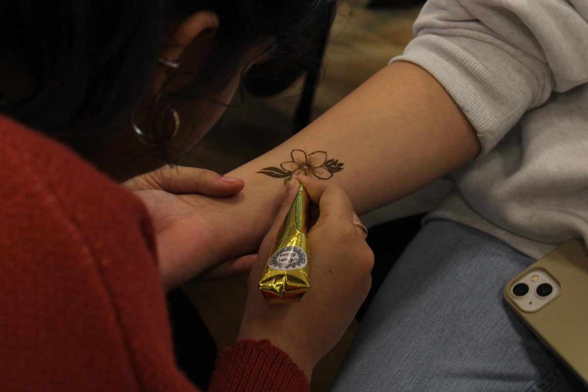 Students at the fair apply henna to their peers. 
