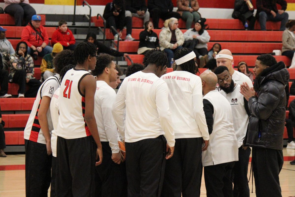 The boy's basketball team in a team huddle before the game.